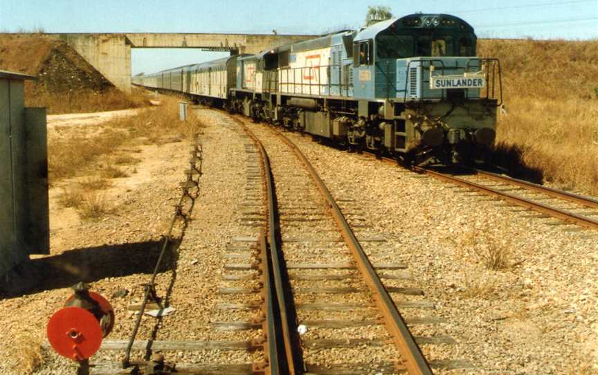 QR loco 1556 and a 1720 class haul the Sunlander northbound through Yabulu, ~1991.jpg