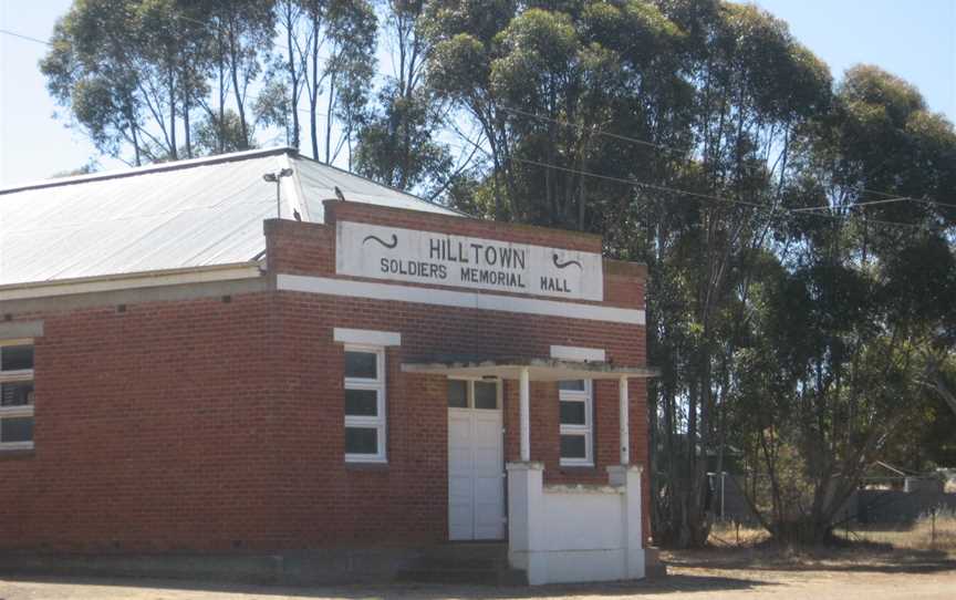 a red brick building with gum trees behind