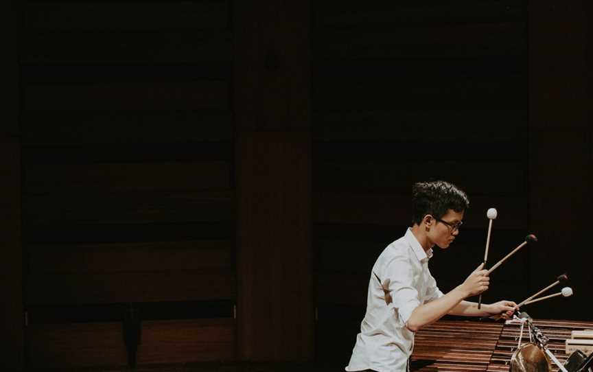 Young person plays a marimba with 4 mallets