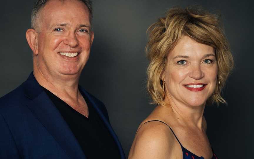 David Wickham, pianist, standing in half profile behind Margaret Blades, violinist, in half profile against grey background