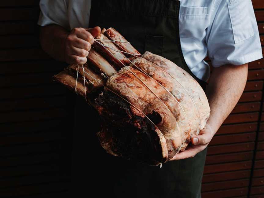 Fraser's Chef holding large meat cut to be cured