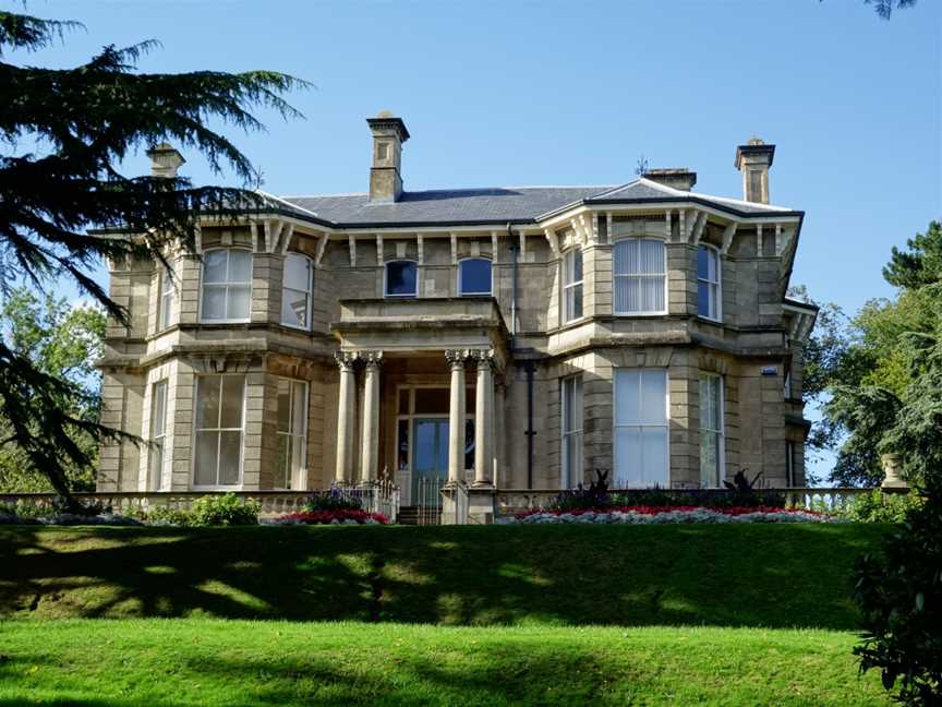 A photograph showing the 19th century bath stone manor house, overlooking the city of Newport and surrounded by the green spaces of the Park