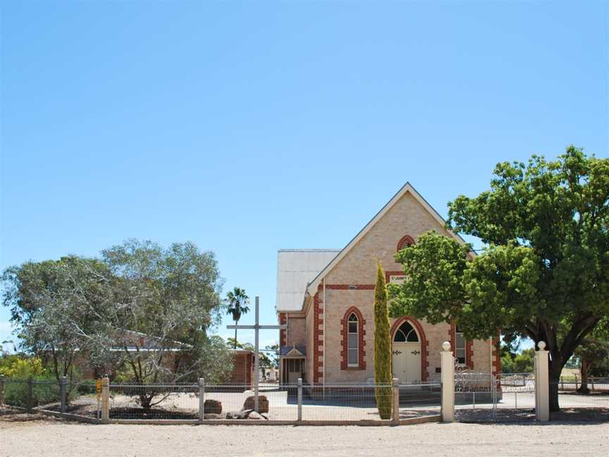 Stone church building with a cross in front