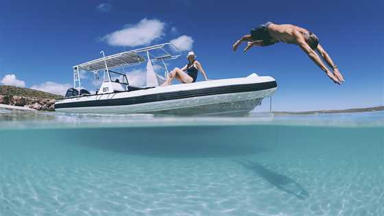 Man diving off a boat at Dirk Hartog Island National Park in the Shark Bay World Heritage Area.<br />